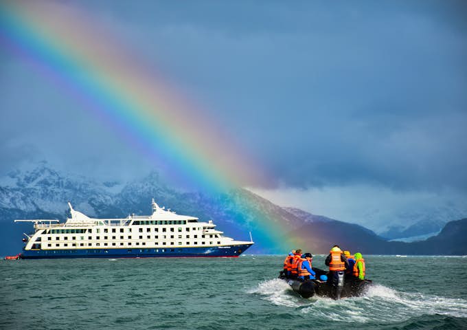 Stella Australis, Patagonian cruising vessel with Zodiac excursion vessel under rainbow, Patagonia