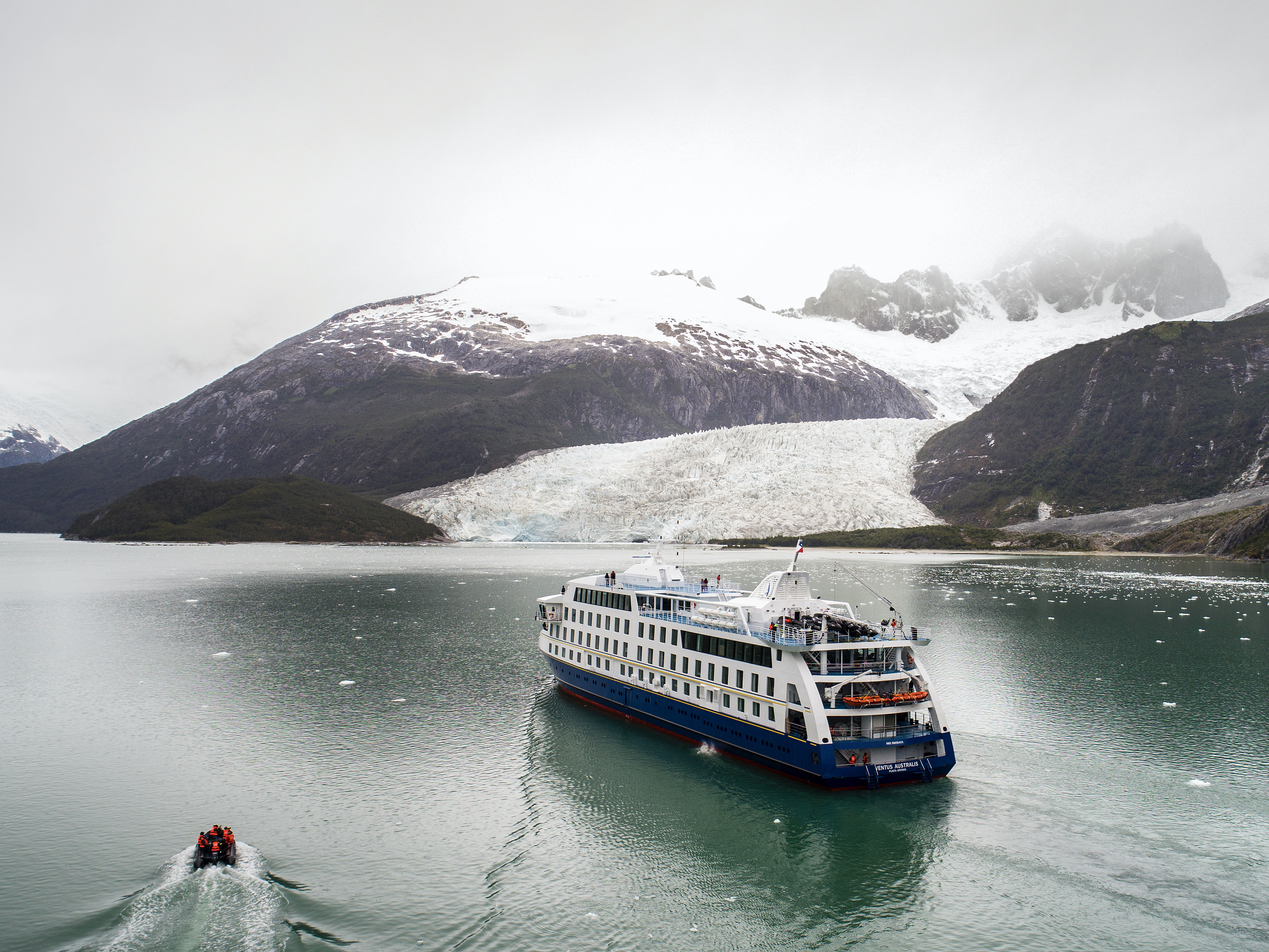 Australis cruise ship Ventus amid the mountains and glaciers of the Darwin range in Tierra del Fuego. 
