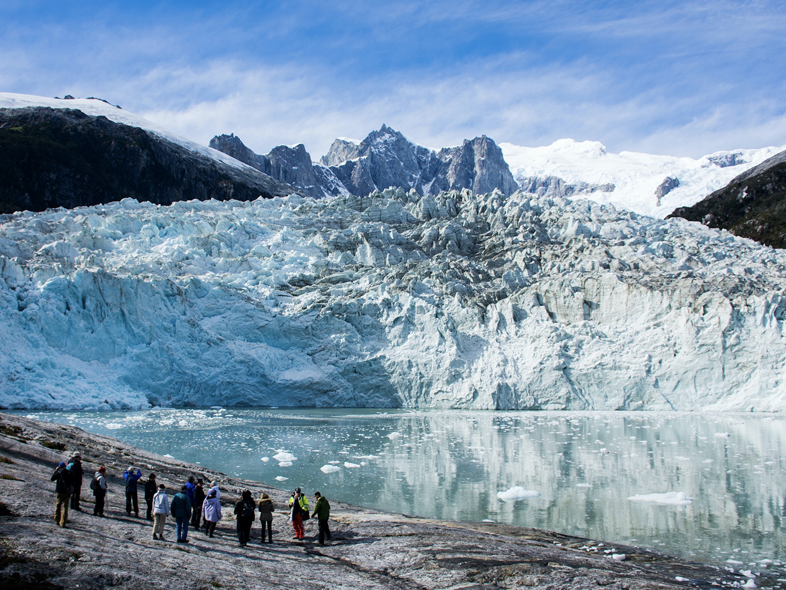 Tourists walk on the beach opposite Pia Glacier in Tierra del Fuego on an Australis cruise