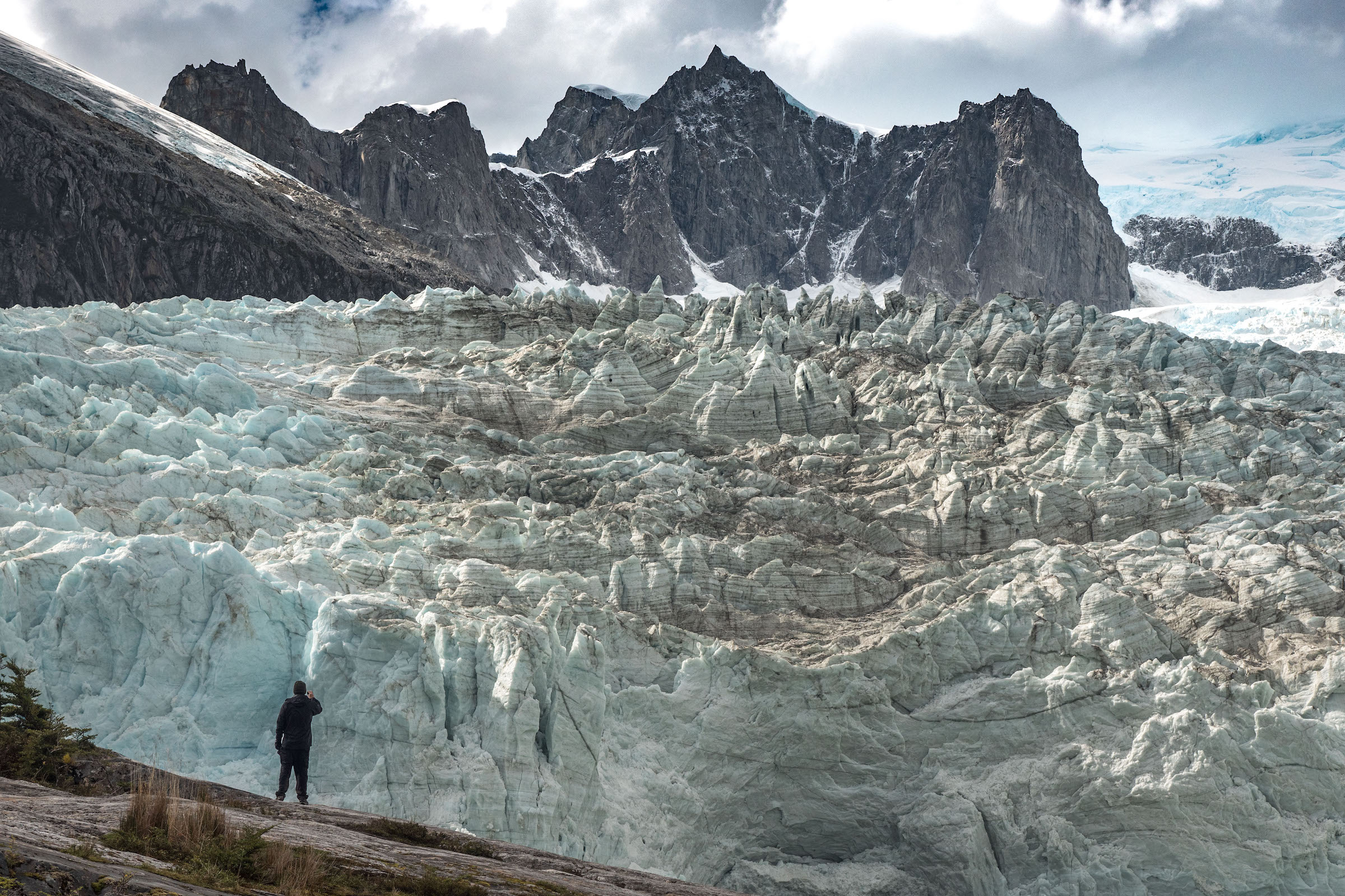 A hiker is dwarfed by a glacier in Tierra del Fuego