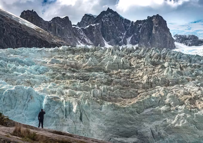A hiker is dwarfed by a glacier in Tierra del Fuego