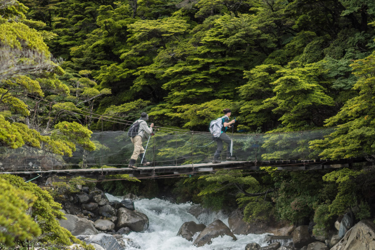 Two hikers on a bridge crossing in French Valley in Torres del Paine