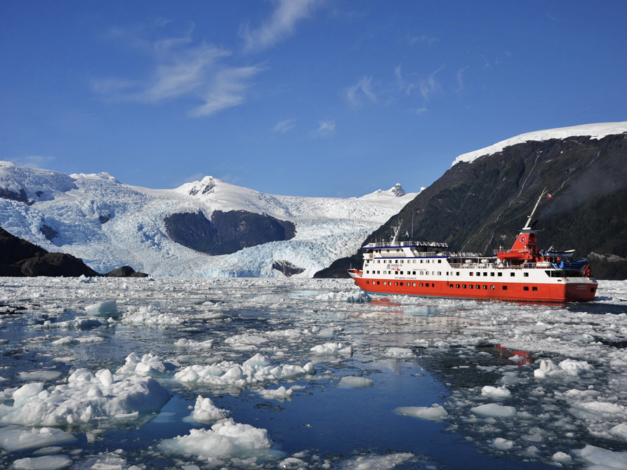 Skorpios III ship in the Southern Chilean Fjords, cruising near an glacier