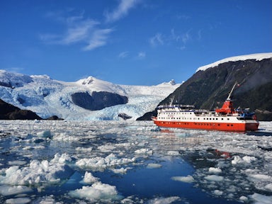 Skorpios III ship in the Southern Chilean Fjords, cruising near an glacier