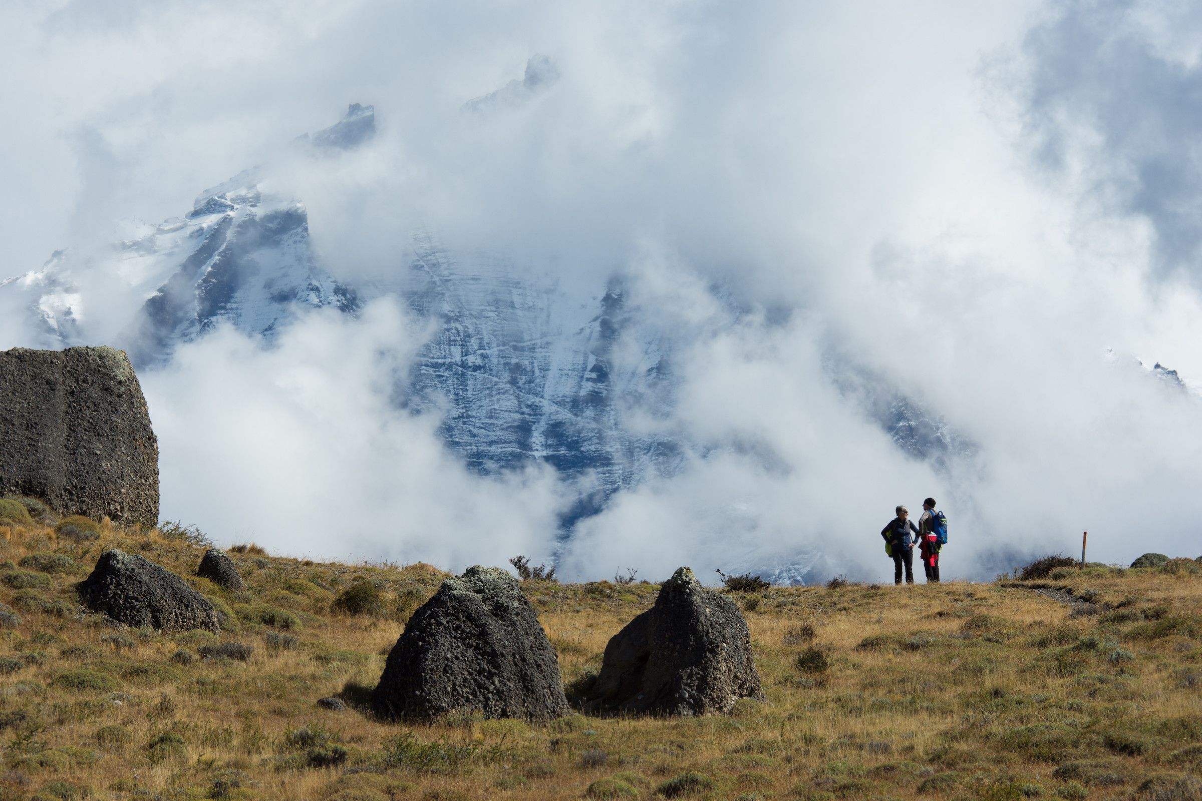 Hikers with Torres del Paine massif in clouds