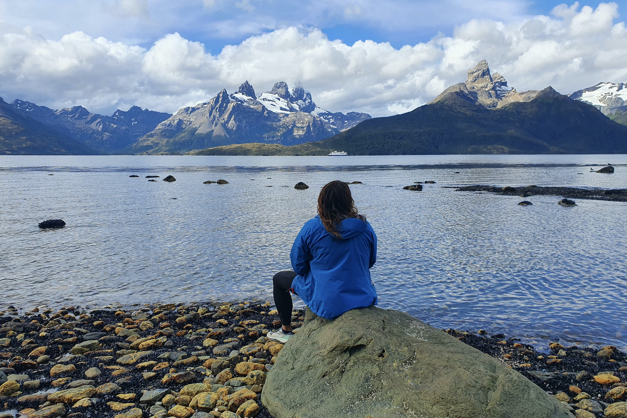 Tourist looking across water and mountains in Tierra del Fuego