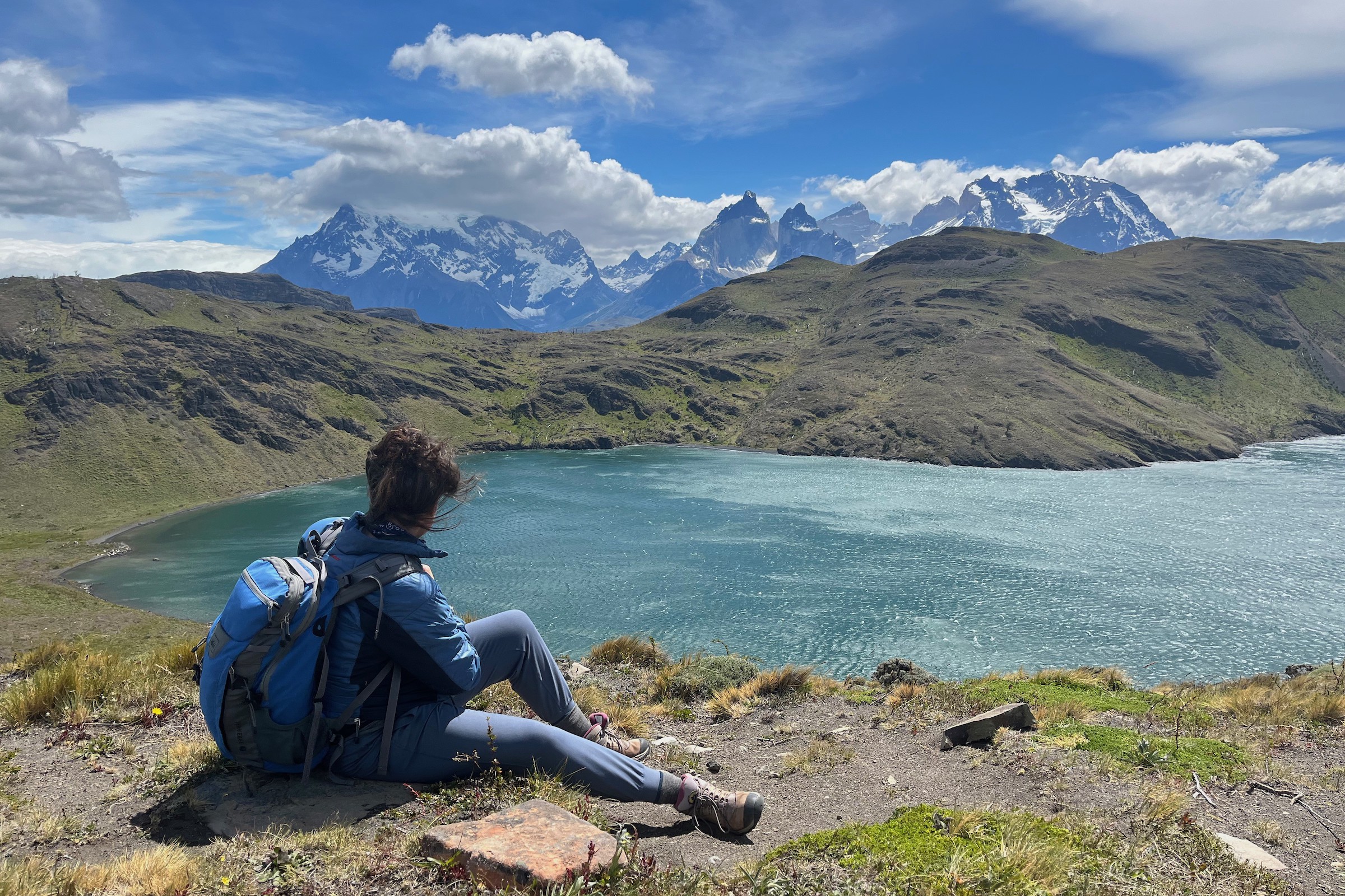 Hiker enjoying views over lake to the Paine Massif