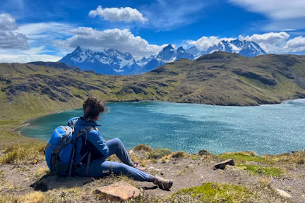 Hiker enjoying views over lake to the Paine Massif