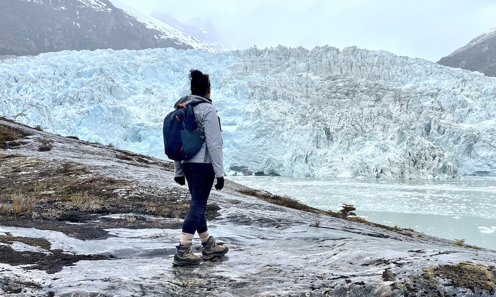 Tourist at glacier on Australis cruise around Tierra del Fuego