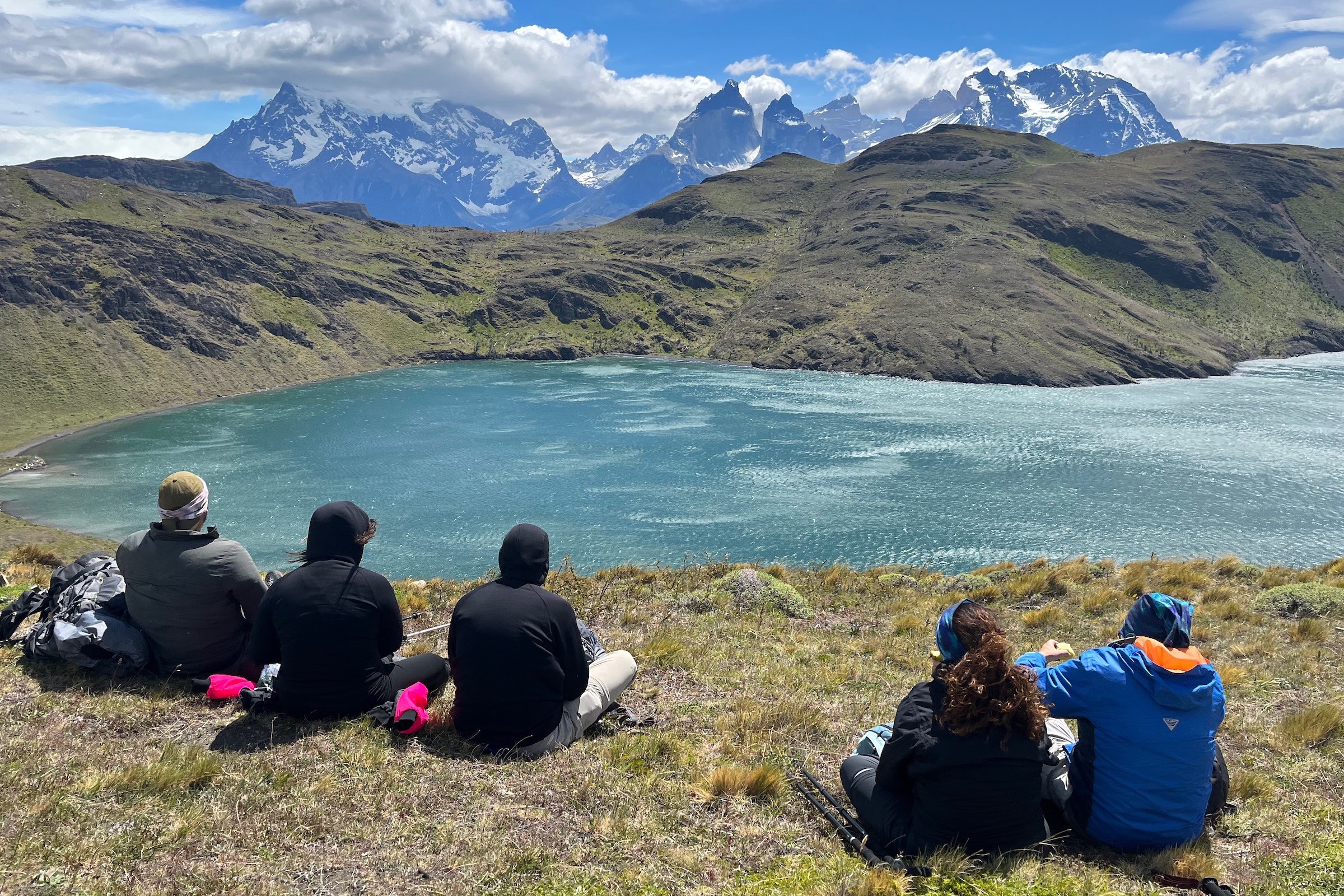 Hikers looking over a lake to the Paine Massif