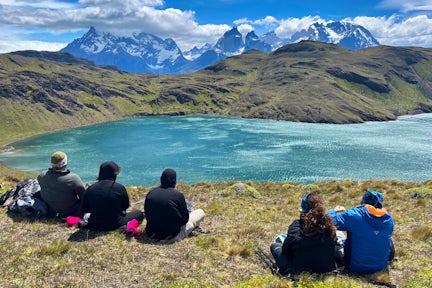 Hikers looking over a lake to the Paine Massif