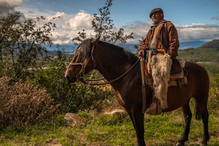 A Chilean gaucho sits on his horse in Aysen