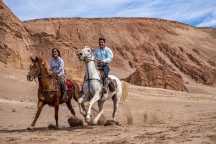 Horse riding across the sand, Atacama, Chile