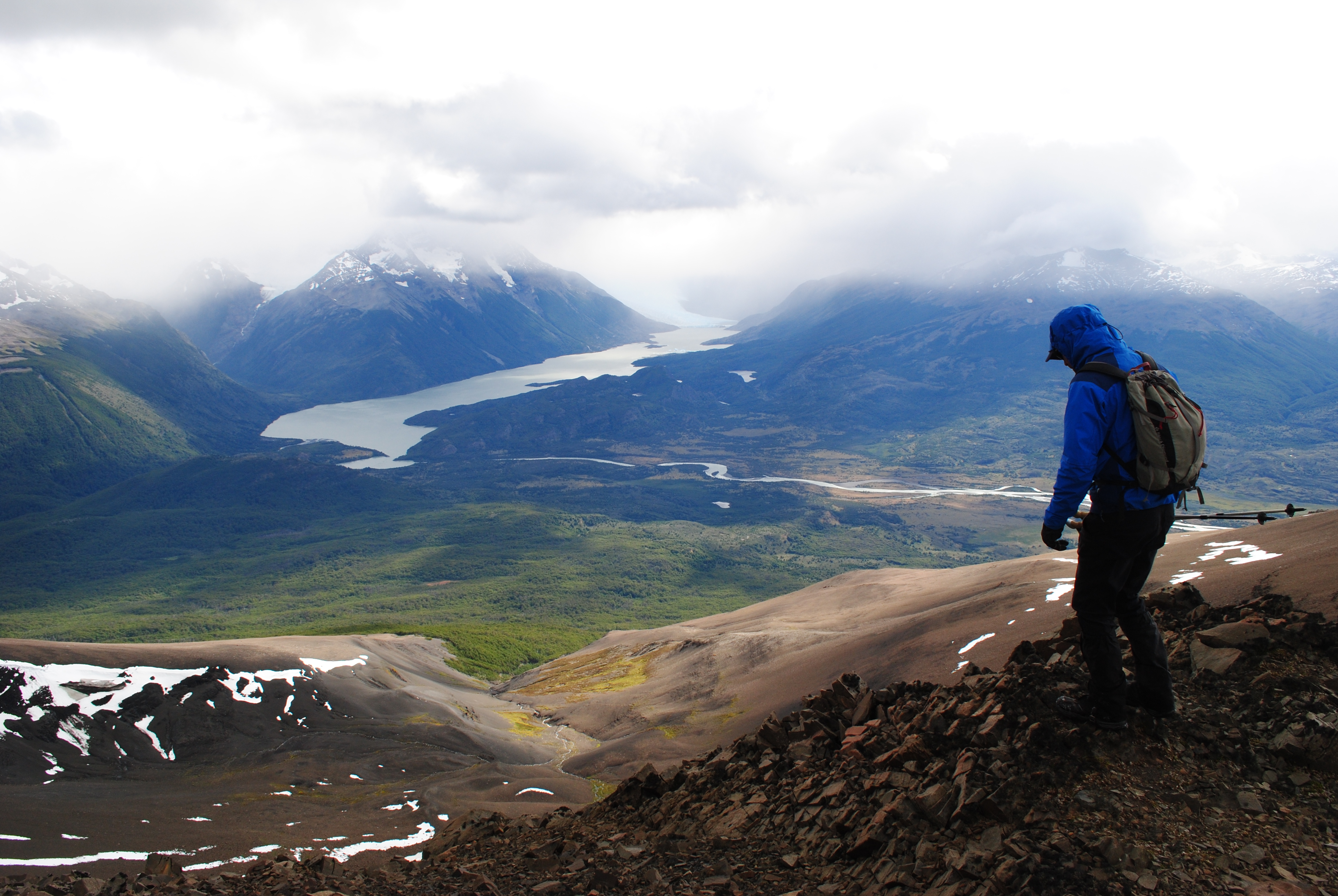 One hiker on a rocky path overlooking lakes and mountains in Torres del Paine National Park. Torres del Paine hike, Chile
