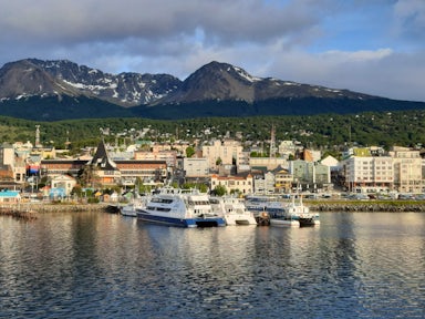 View from the sea of boats in the dock Ushuaia in Argentina, with a backdrop of mountains