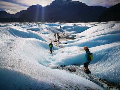Hikers walking in the sunshine on top of the Exploradores glacier in Aysen Chile