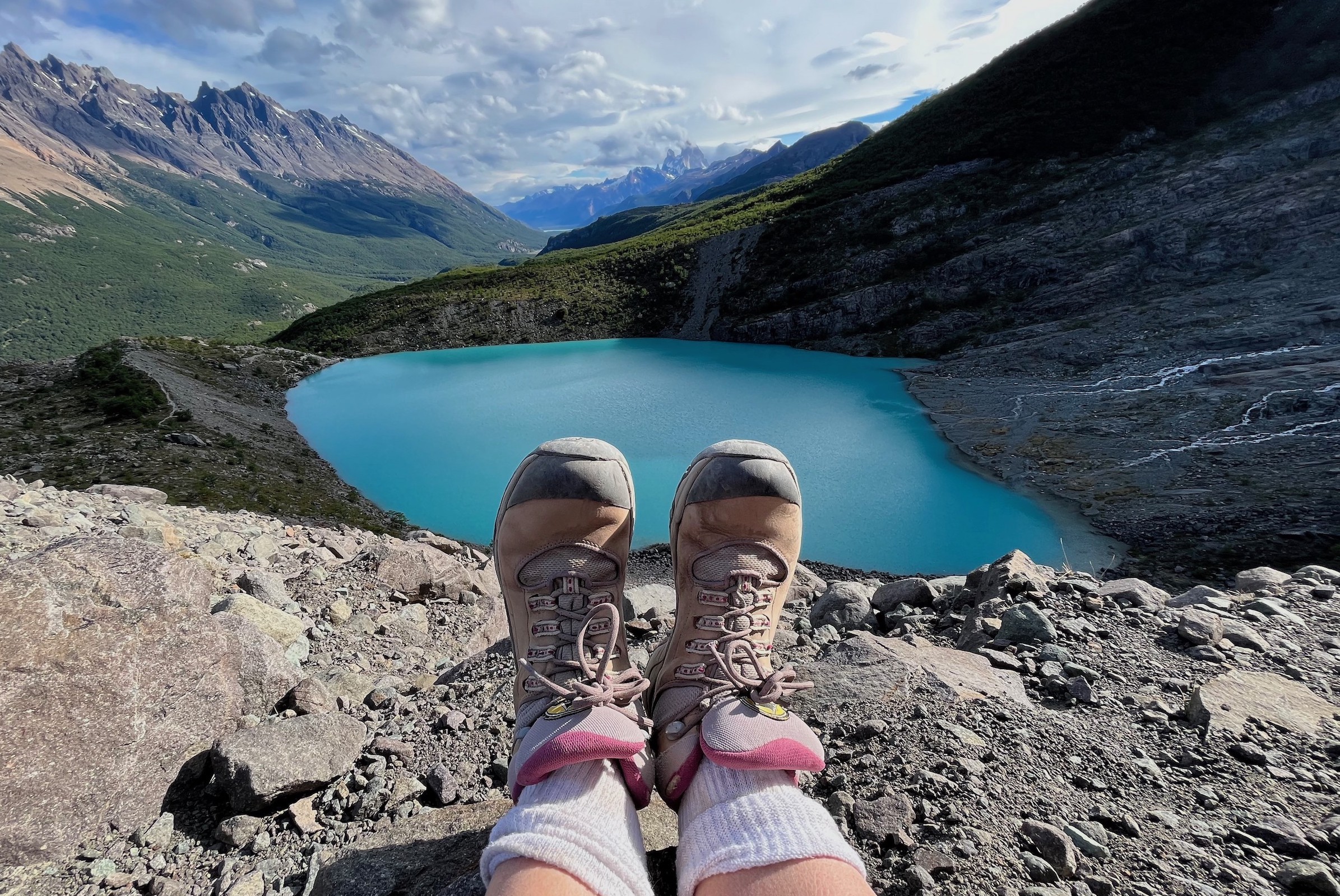 View over a hiker's feet to the Humuel glacier lake near Lago del Desierto