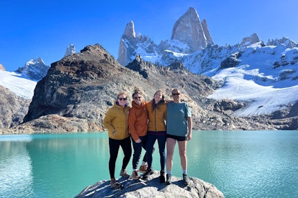Four hikers at Laguna de Los Tres under Mount Fitz Roy in Los Glaciares