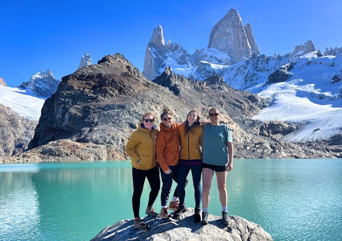 Four hikers at Laguna de Los Tres under Mount Fitz Roy in Los Glaciares