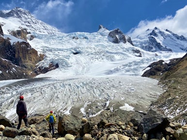 Hikers descend through mountains to the tongue of Cagliero Glacier near El Chalten Argentina