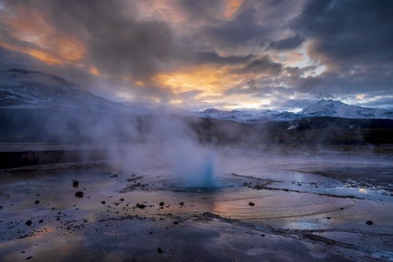 It is dawn. The El Tatio geysers explode with steam into the freezing air. There is a colourful sunrise on the horizon, framed by mountains. This is the altiplano above Chile's Atacama Desert.